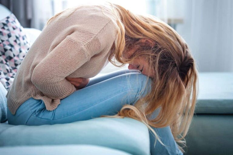 giovane donna con dolore all'addome: come alleviare i dolori mestruali